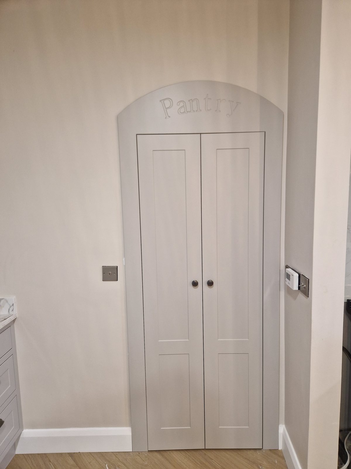 Arched walk-in pantry doors with engraved Pantry detail