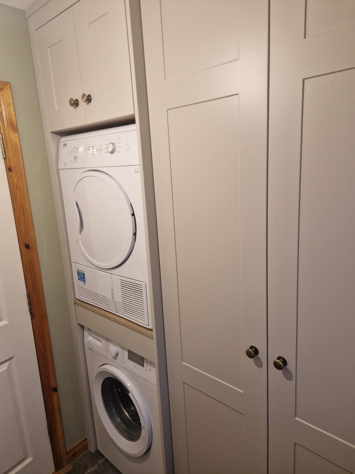 Fitted cream utility room with built-in washer and dryer